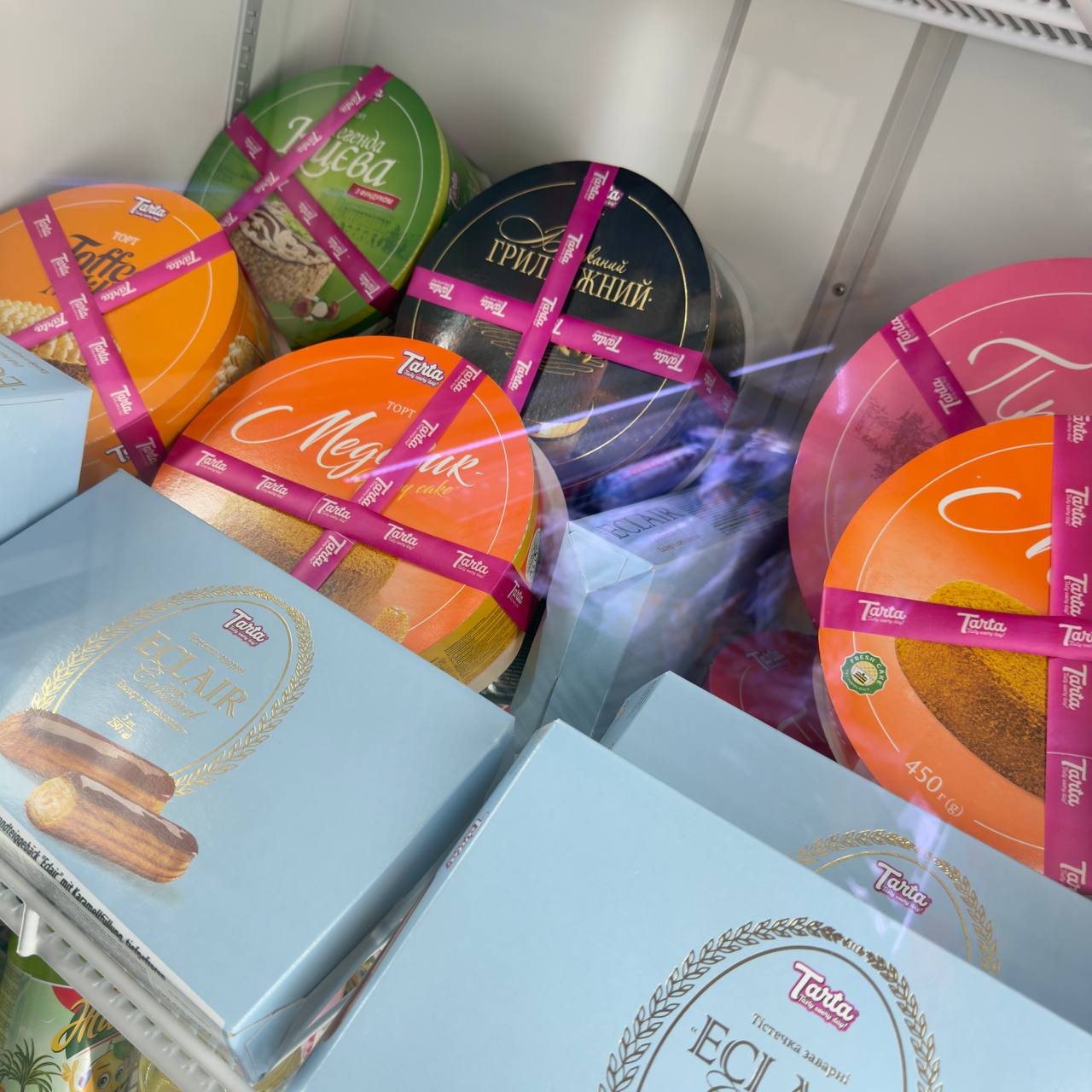 Torty i ciasta w pudełkach w lodówce cukierniczej